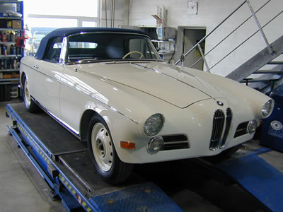 Klassisches weißes BMW-Coupé auf Hebebühne in Werkstatt